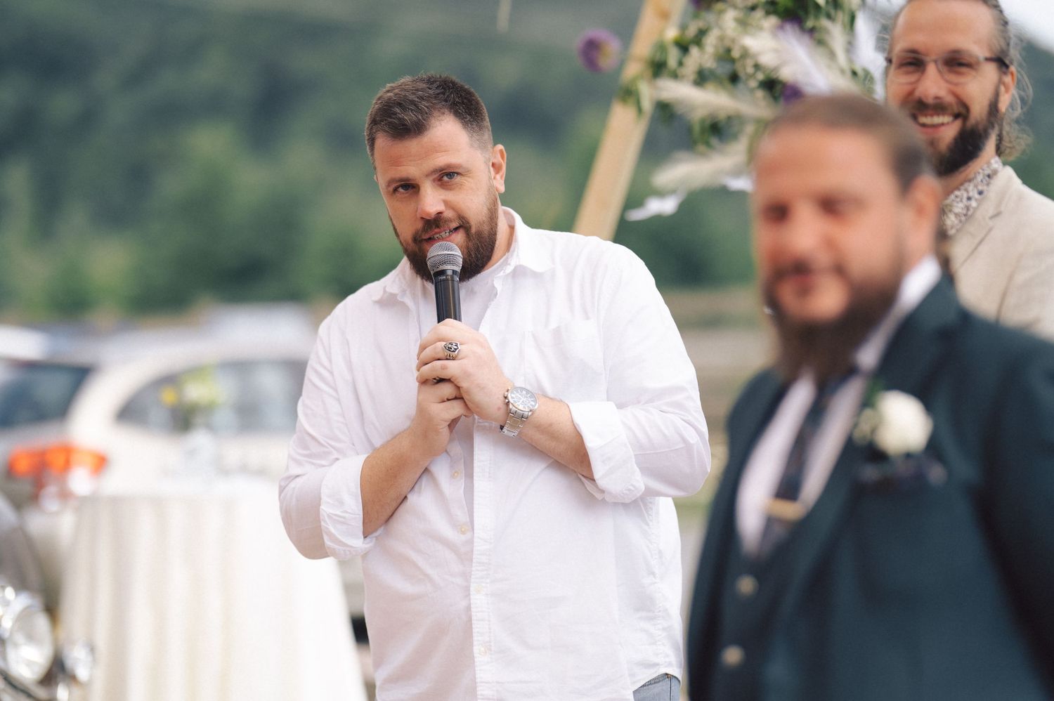 A group in white dress shirts and dark suits gather during what appears to be a formal event or wedding celebration.