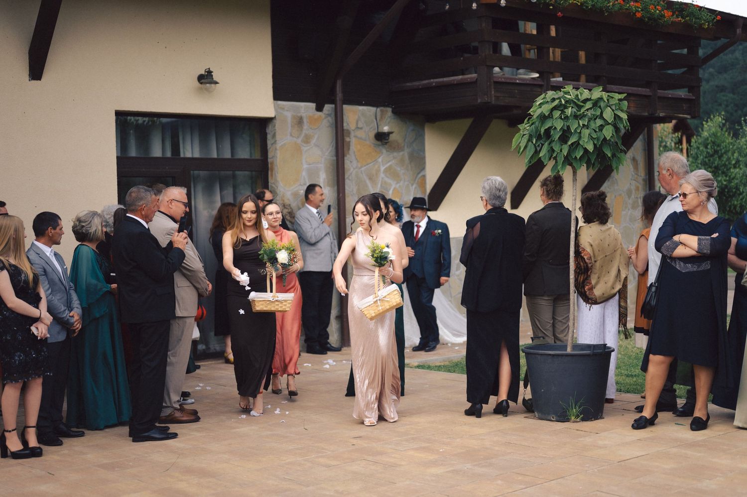 A group of wedding guests mingling on an outdoor patio during a social gathering.