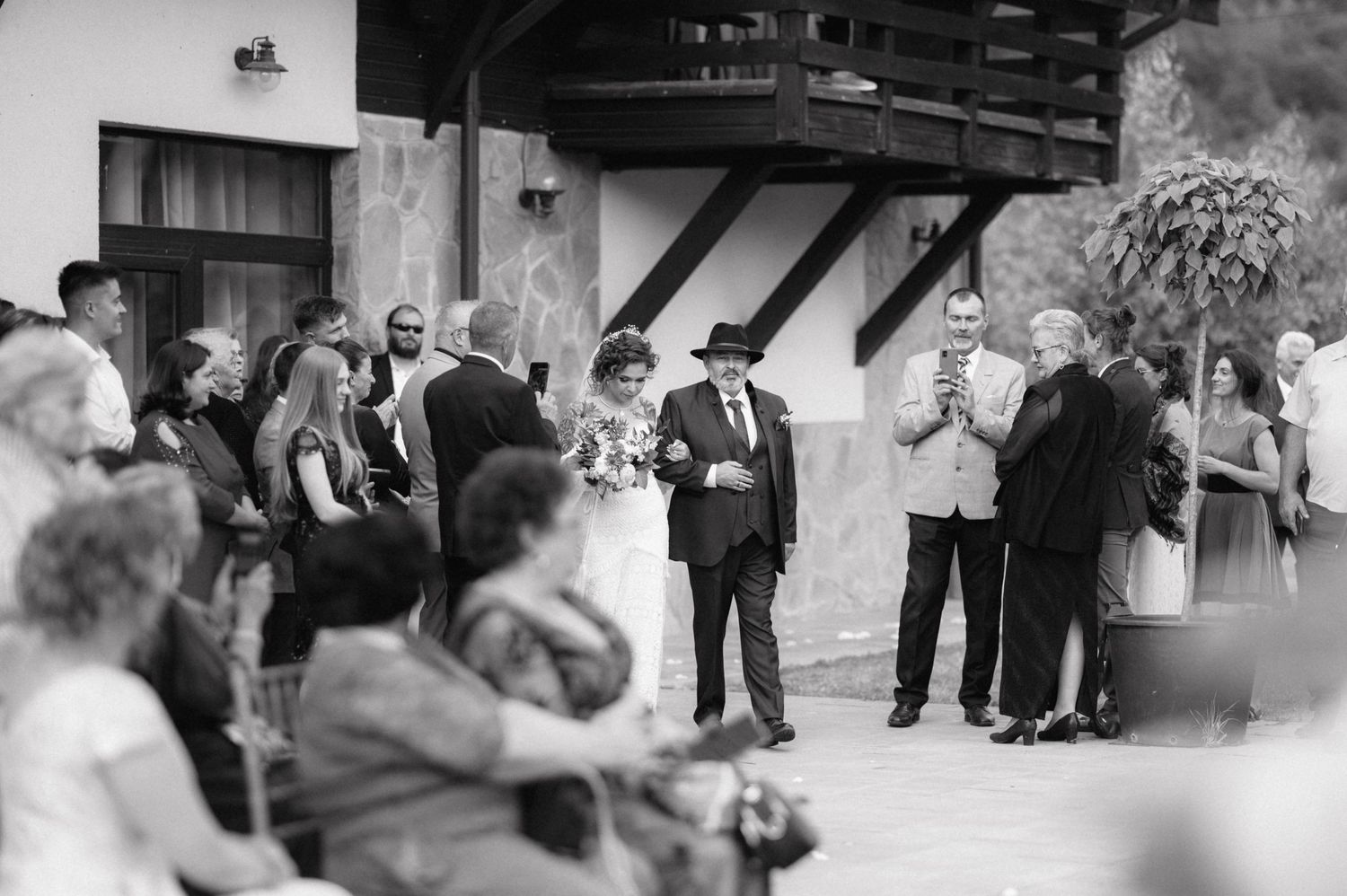 Wedding guests gather at an outdoor venue for a black and white reception celebration.