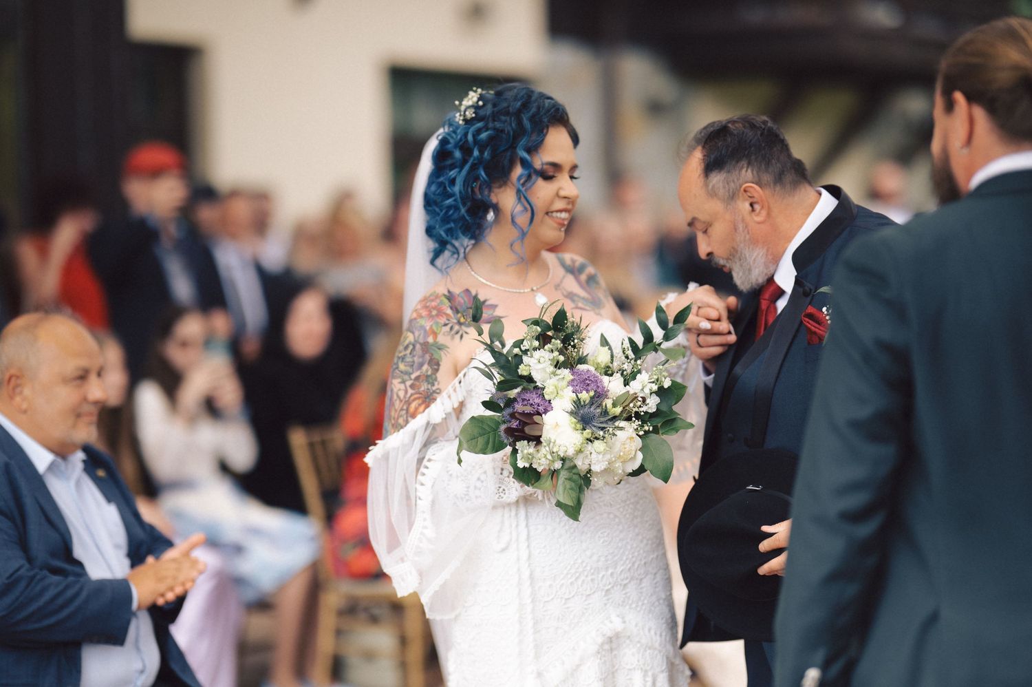 A joyful moment shared between newlyweds during an outdoor wedding ceremony with guests looking on.