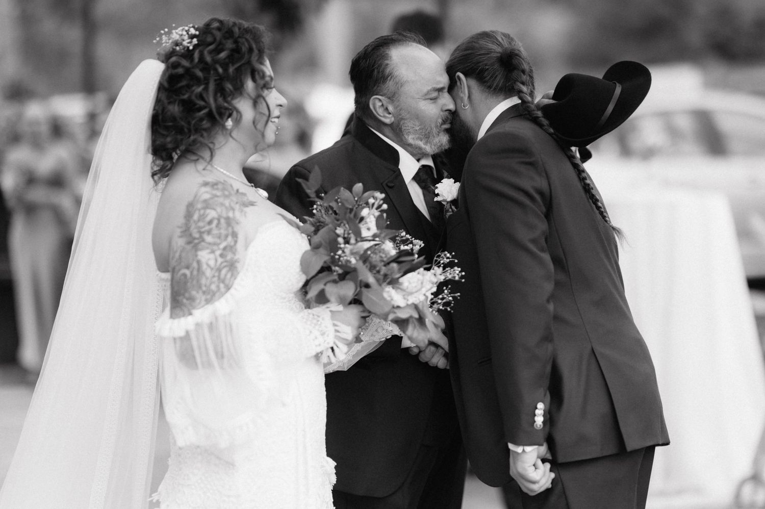 A tender moment captured during a wedding ceremony with a black and white artistic style.