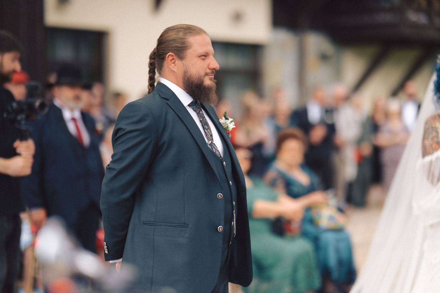 A wedding ceremony participant stands outdoors addressing guests during the celebration.