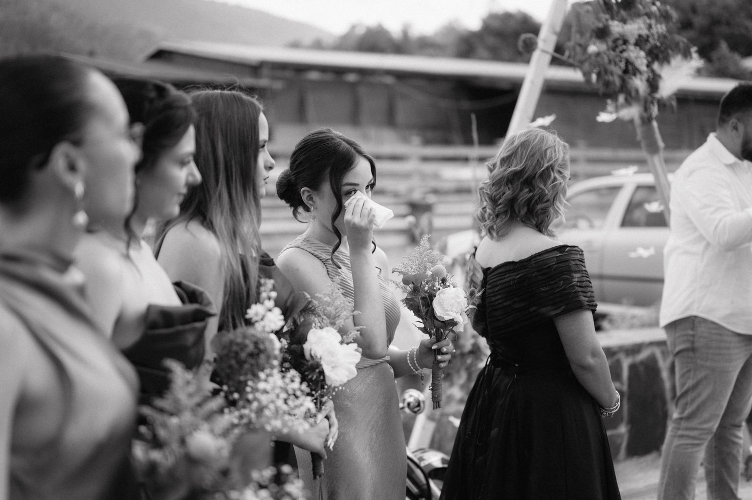 Black and white photo of outdoor wedding celebration with natural decor elements.