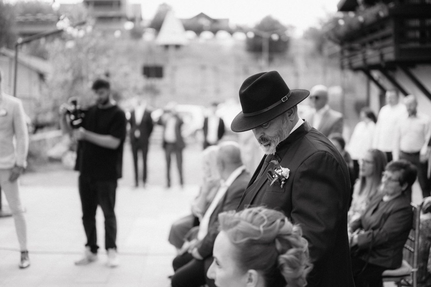 Black and white photograph of wedding celebrants mingling during an outdoor reception.