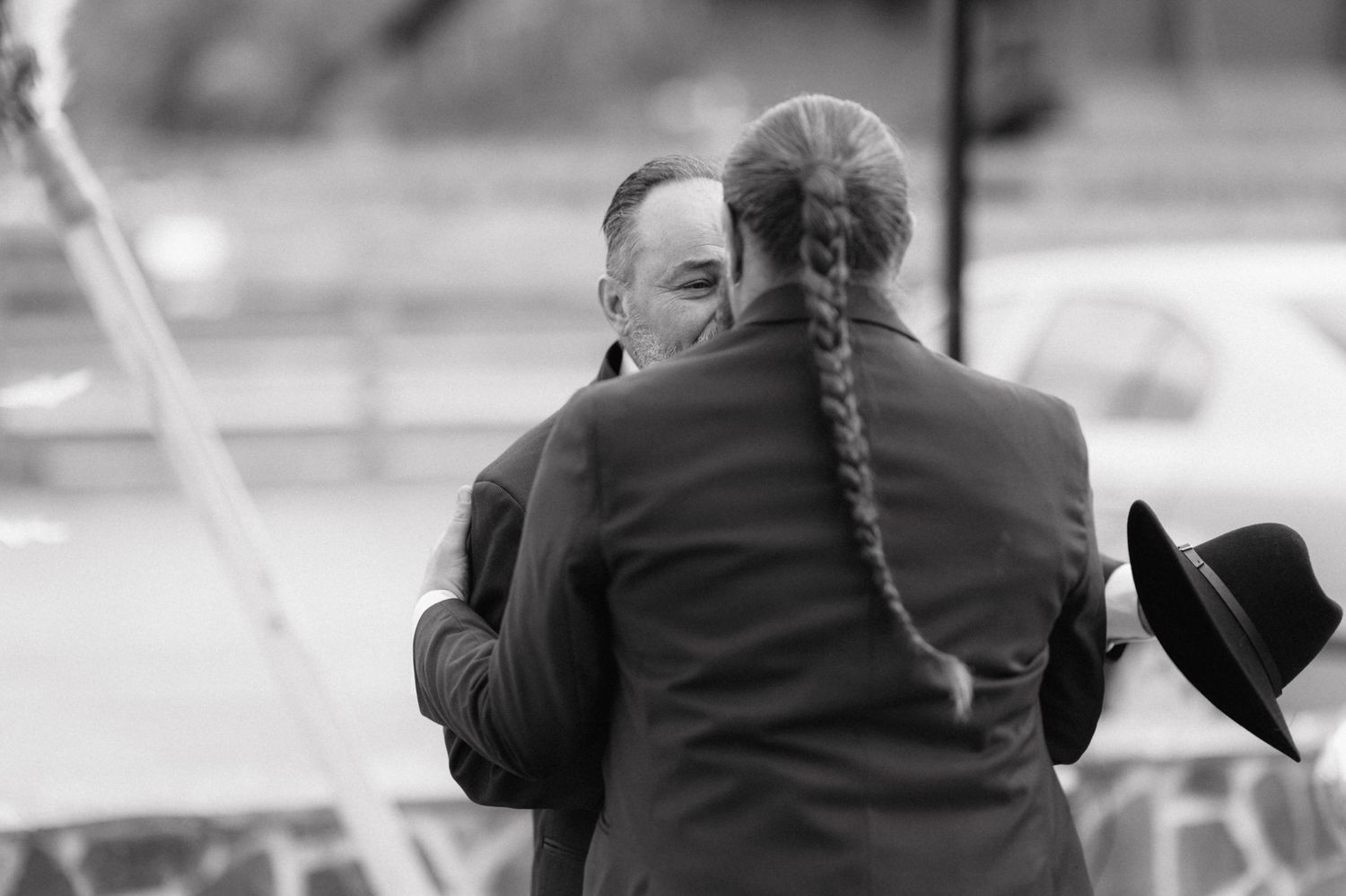 A group of people huddle together in an emotional embrace during what appears to be an important ceremony or event.