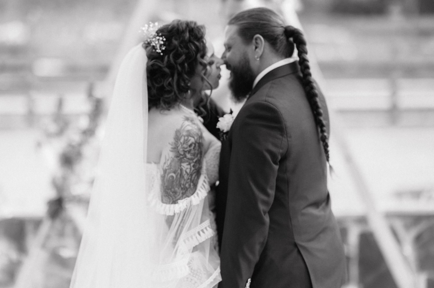 Black and white wedding photo of newlyweds sharing an intimate moment together during their ceremony.