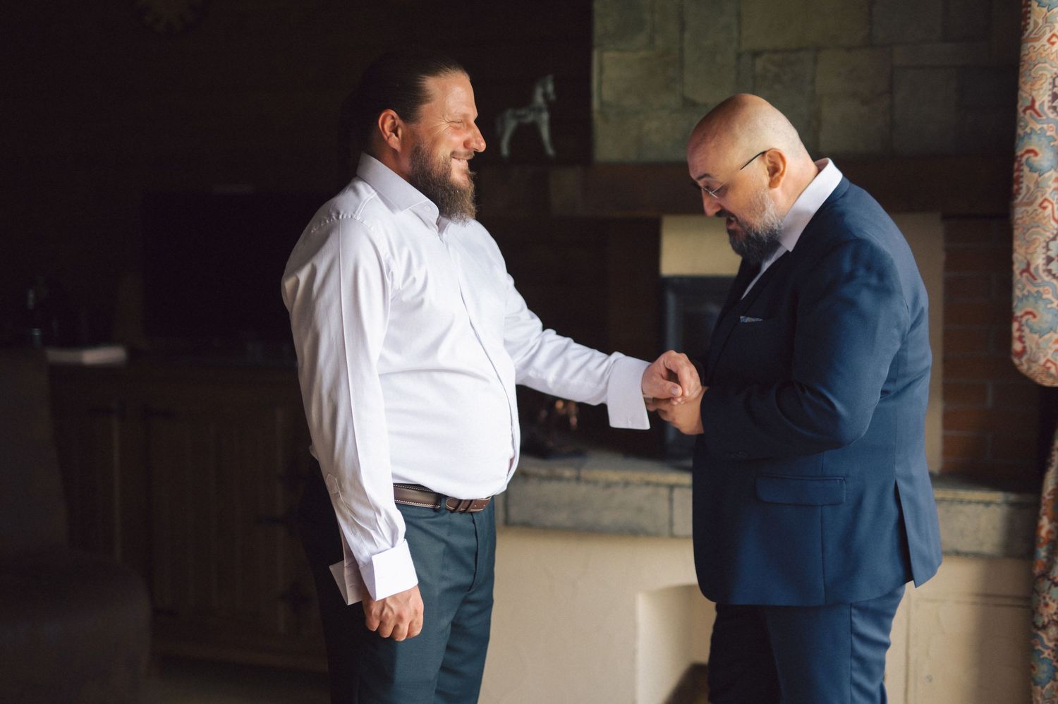 Two professionals in business attire exchange documents and shake hands in an office setting.