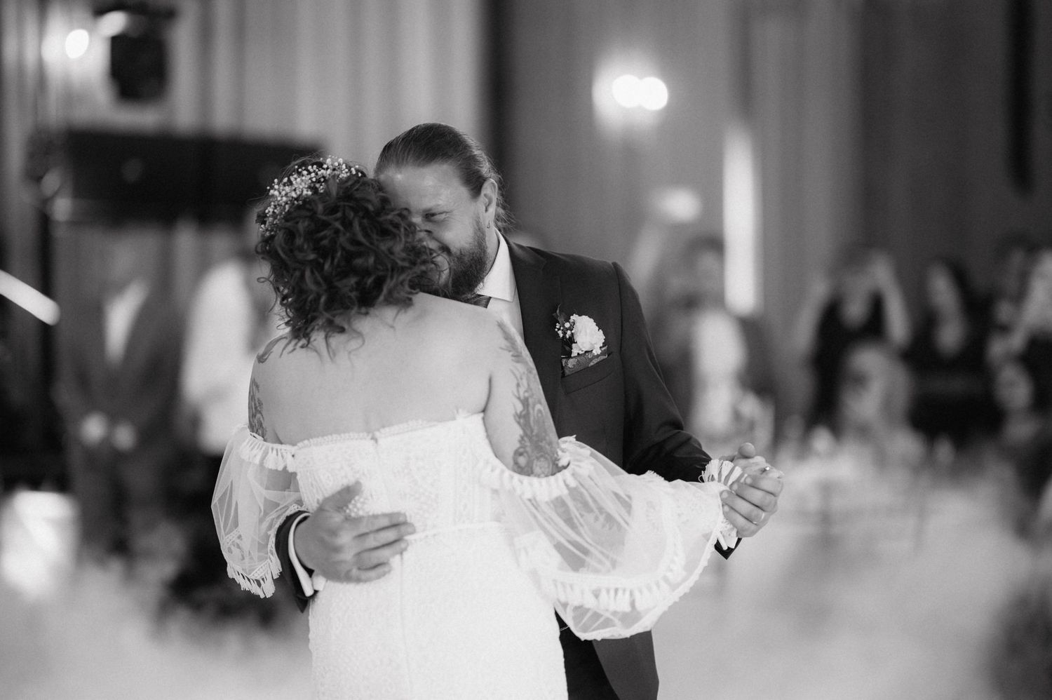 A couple shares their first dance as newlyweds on a misty dancefloor during their wedding reception.