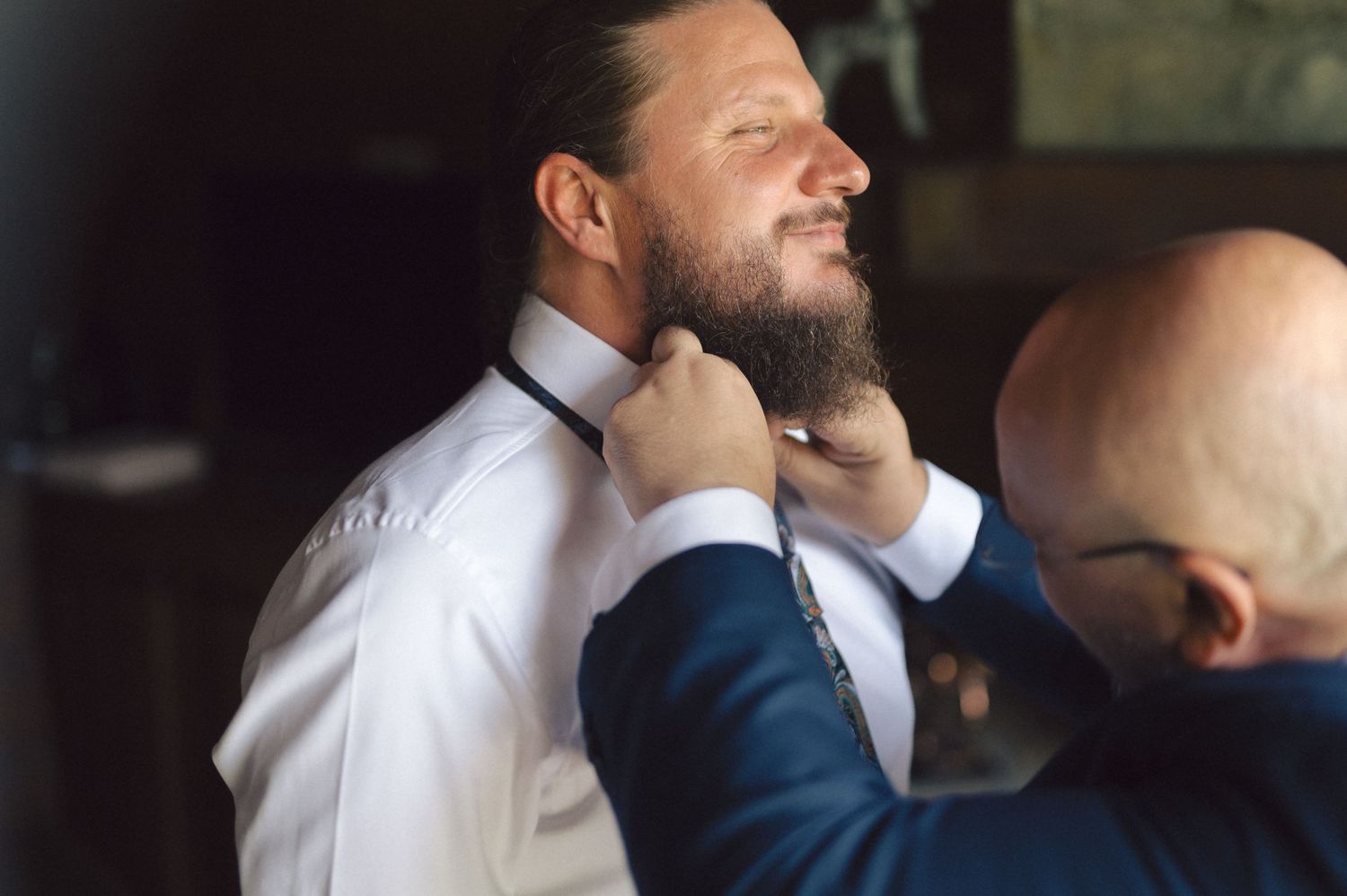Wedding day preparation showing final adjustments being made to formal attire.