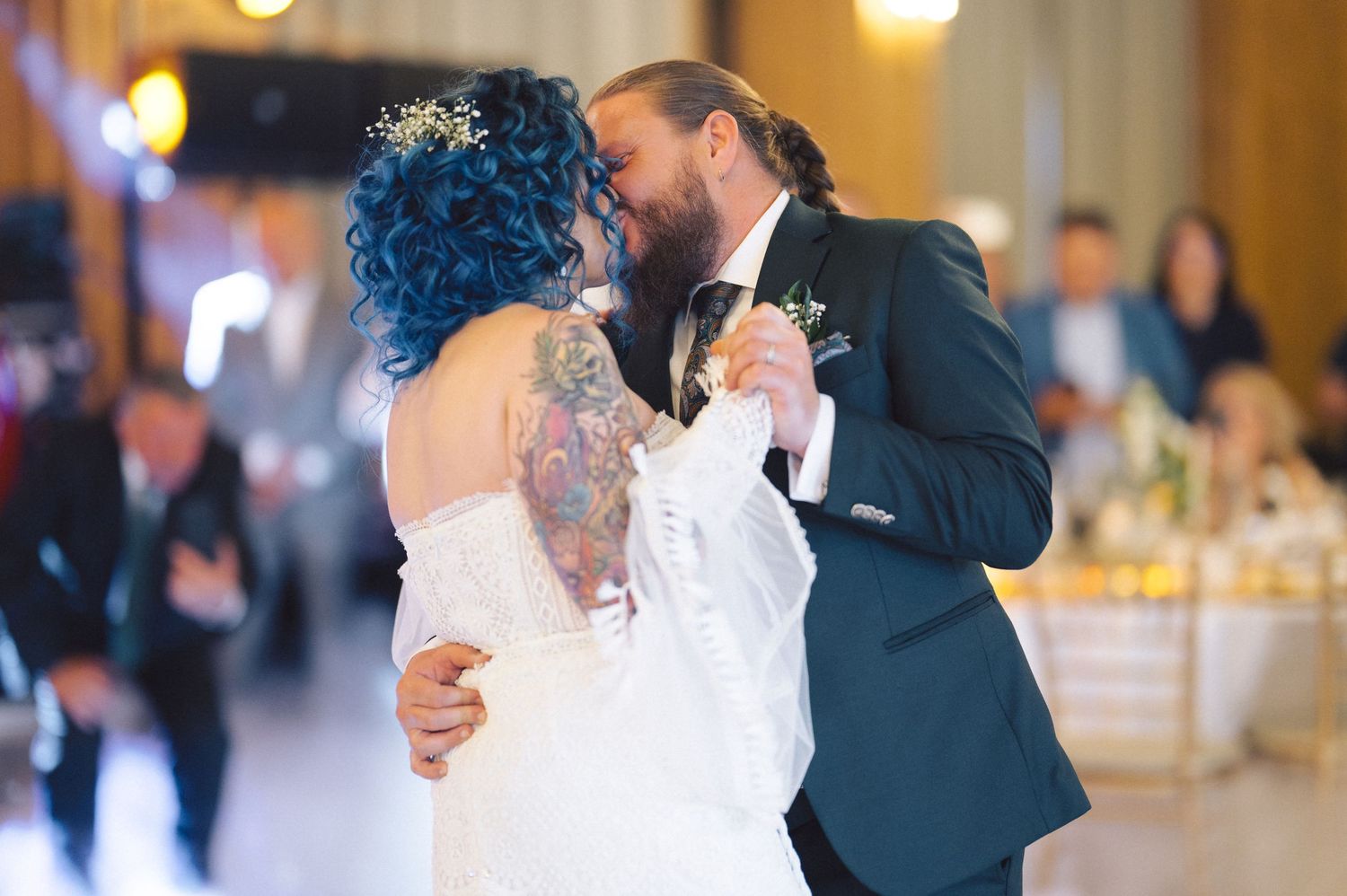 Couples dancing together at an elegant wedding reception in a warmly lit ballroom.