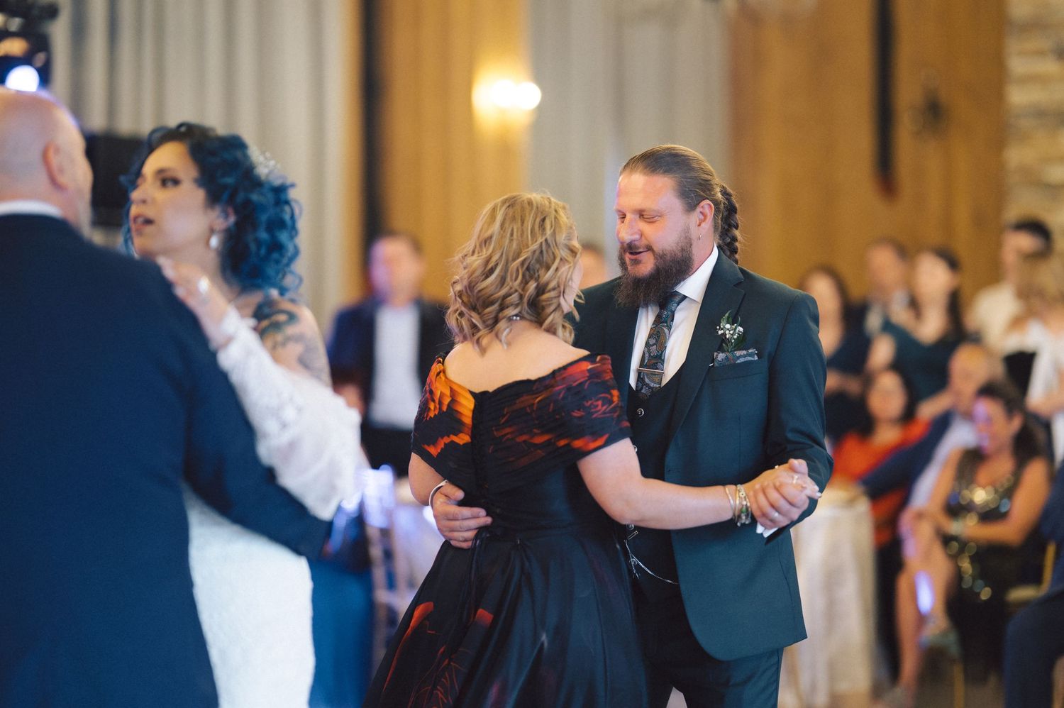 Couples glide gracefully across a grand ballroom dance floor during an elegant evening event.