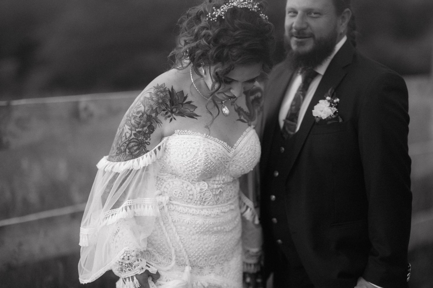 A touching black and white candid moment between newly married couple during their outdoor wedding celebration.