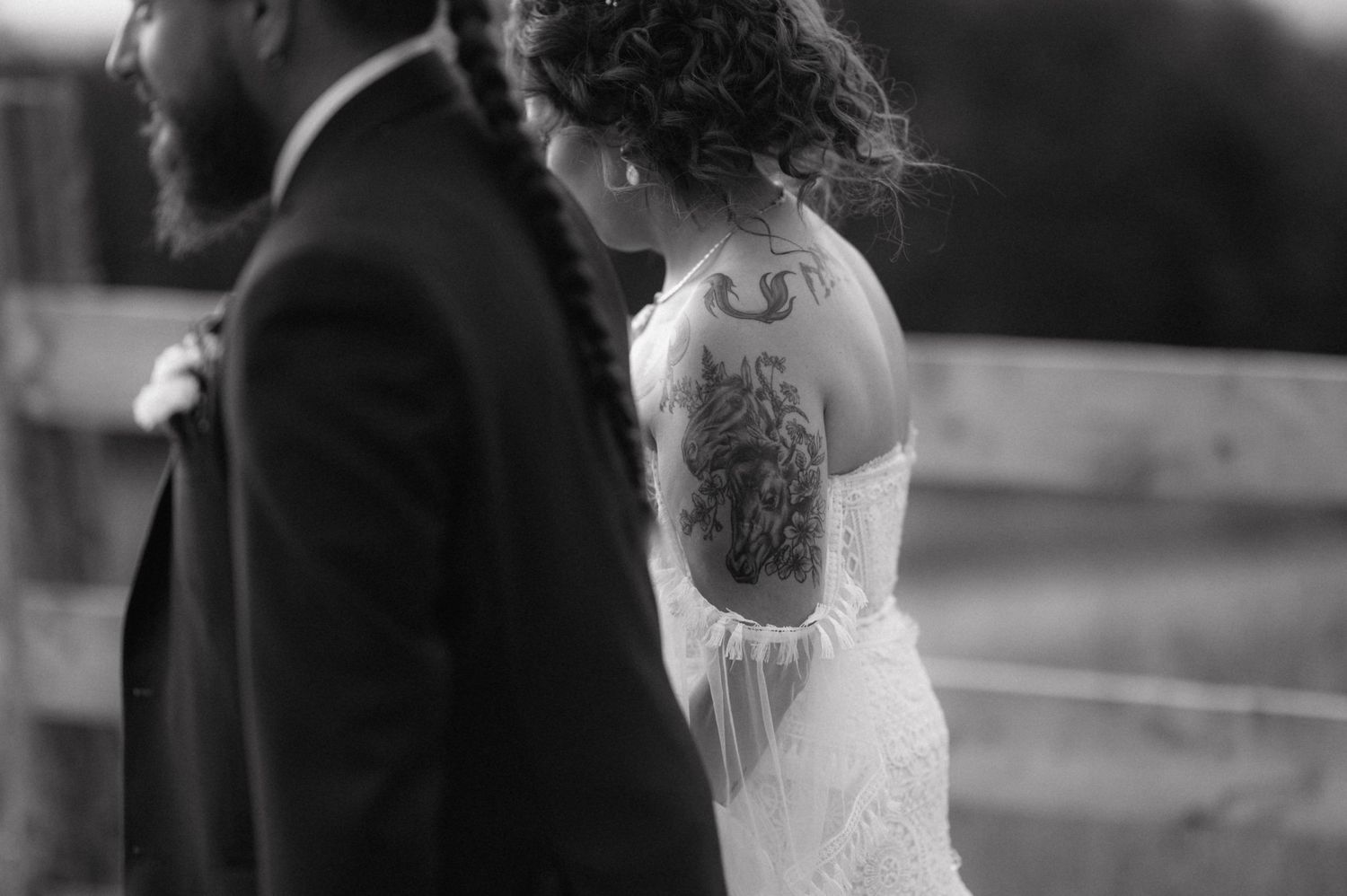 Black and white wedding photo showing couple in intimate dance pose on outdoor stone terrace.
