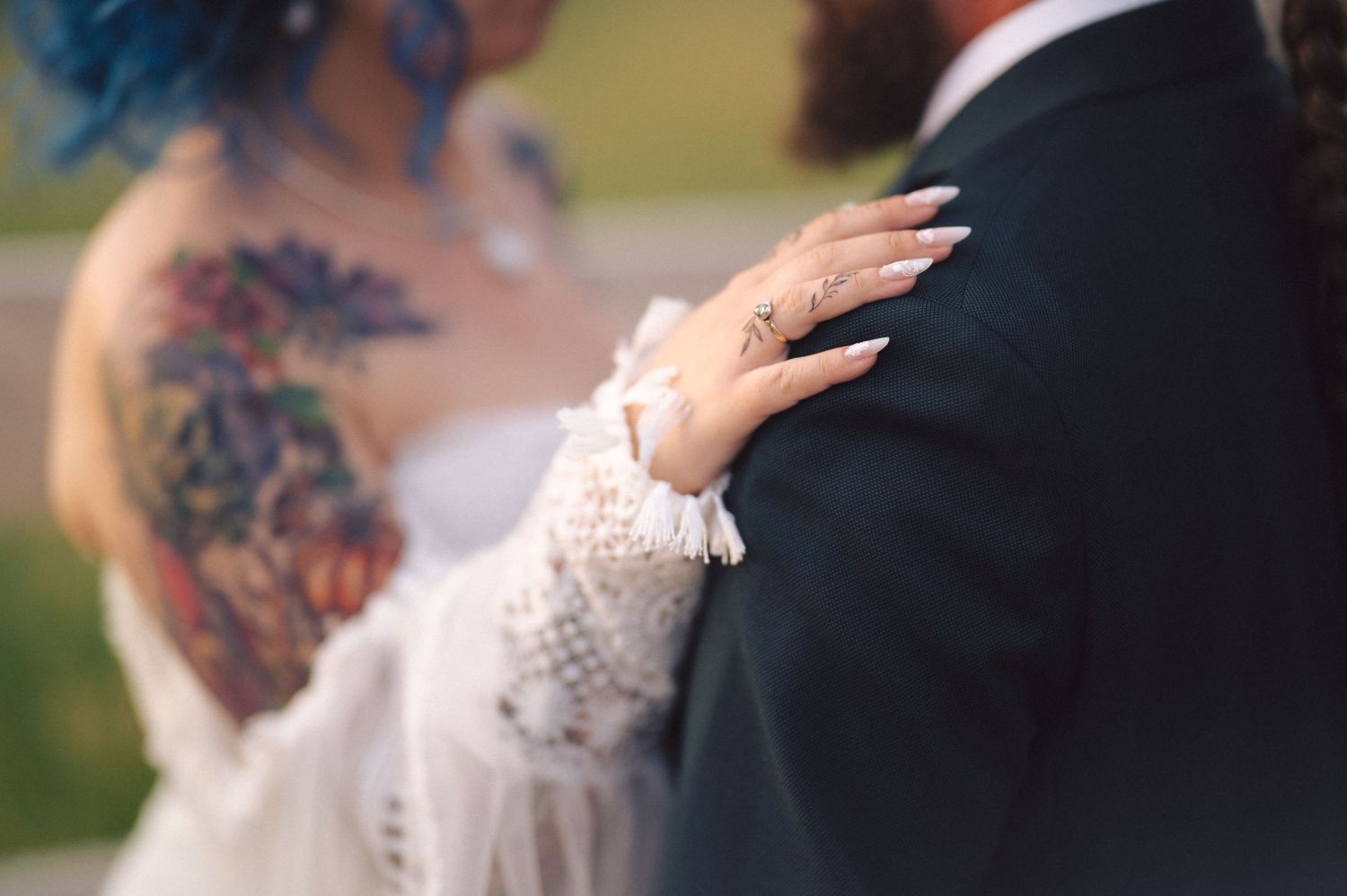 Two people share a romantic moment during their wedding dance while surrounded by guests taking photos.