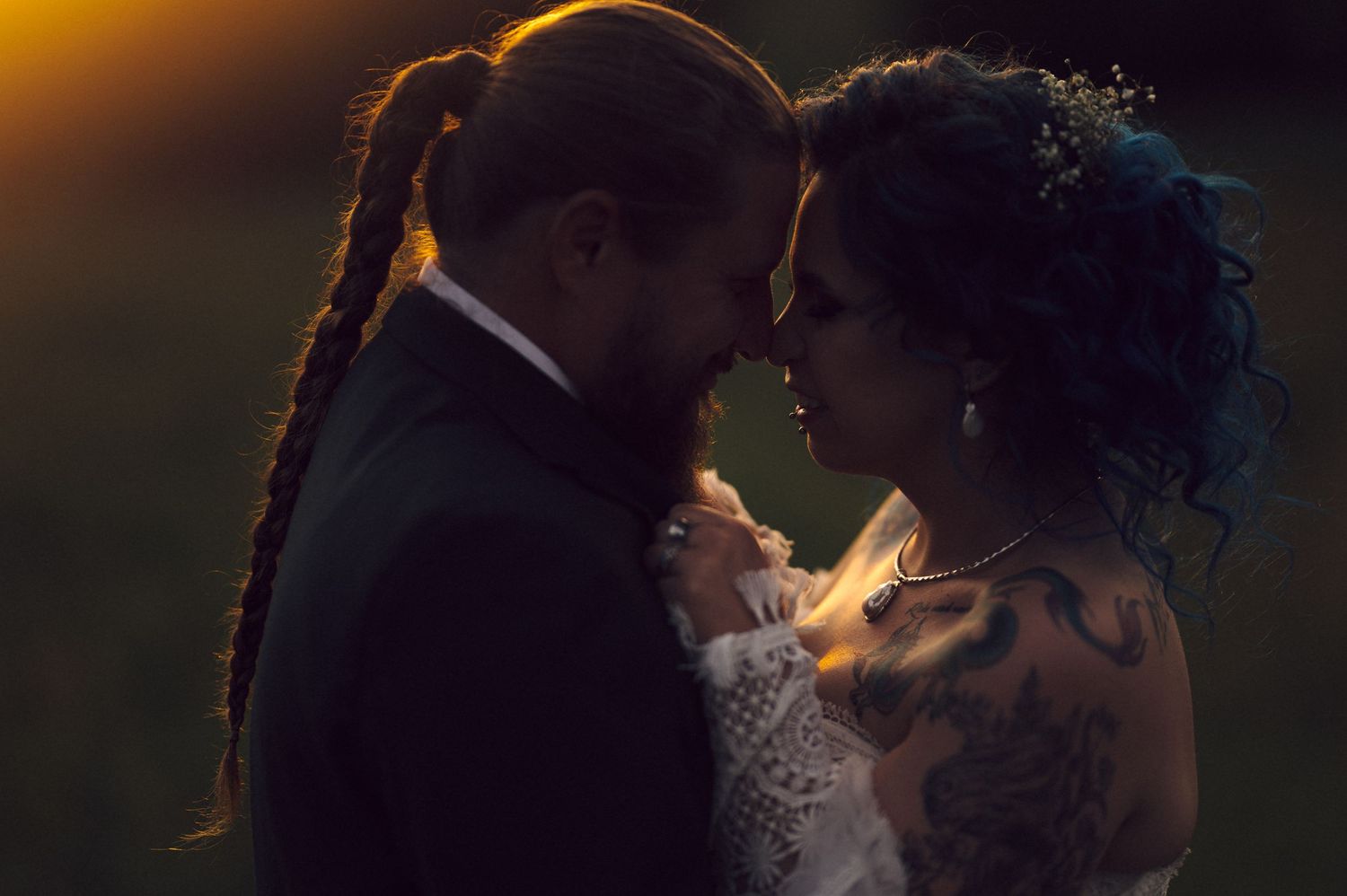 A silhouetted couple shares a romantic moment with dramatic backlit glow illuminating their tender embrace.