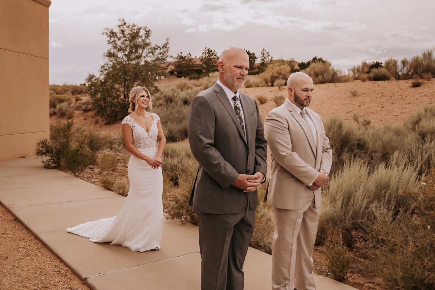 Newlywed couple shares intimate moments in desert landscape during sunset ceremony with warm tones. Santa Fe New Mexico wedding photographer