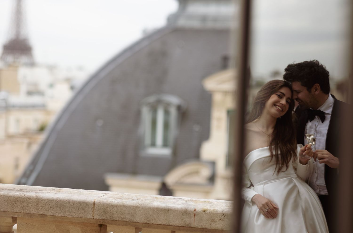 Romantic moment captured on European balcony with domed architecture in background.