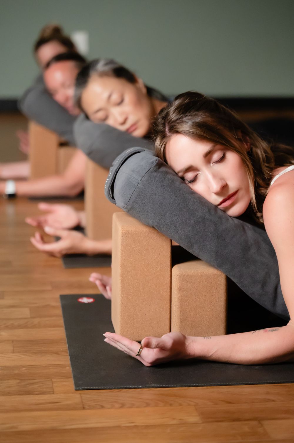 A restful restorative yoga sequence using props and blocks on a hardwood floor.