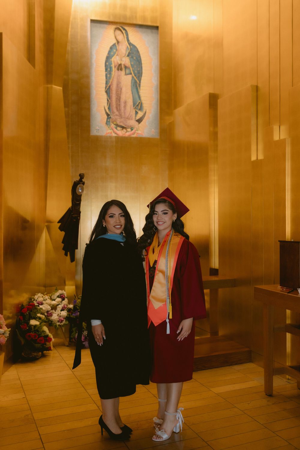 Religious figures' photos line wood-paneled hallway with golden lighting creating a warm, spiritual atmosphere.