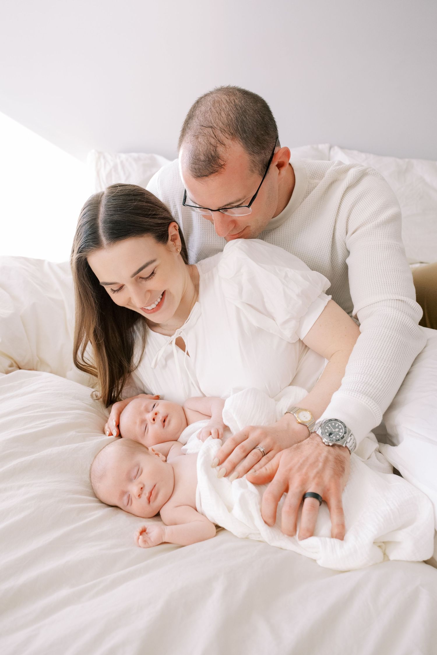 A collection of baby and toddler clothing featuring neutral beige shorts and delicate blush pink tops laid out on a light background.