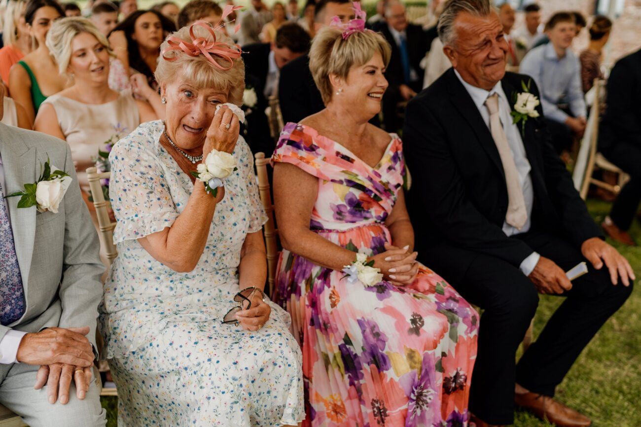 Wedding reception guests mingling and celebrating with drinks in a festive outdoor setting.