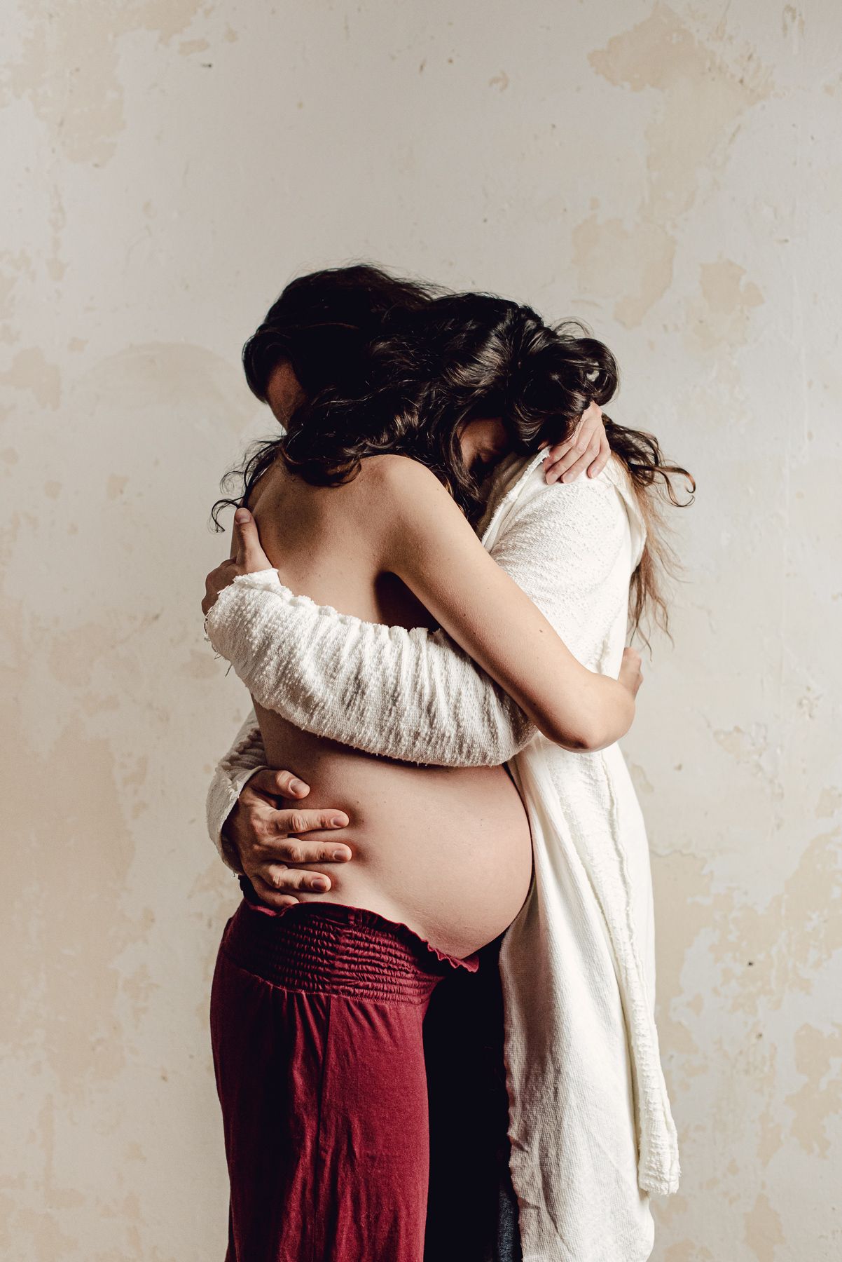 A dramatic series of intimate poses between two people wearing red and white clothing against a neutral wall background.