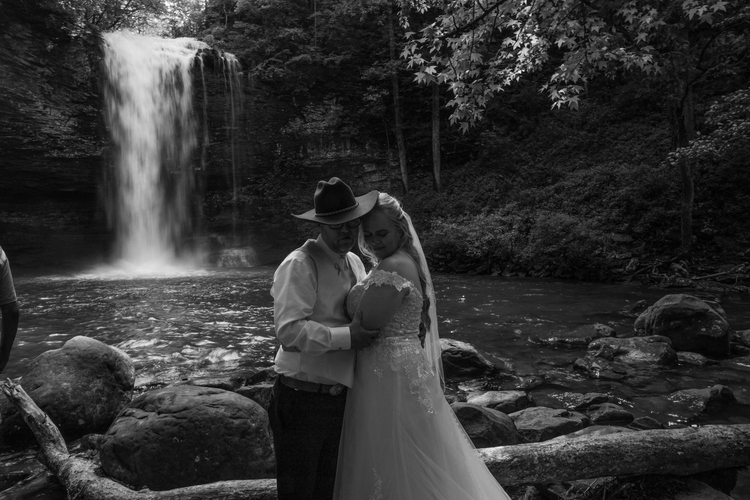bride and groom have their wedding photographer capture a wedding portrait in front of a waterfall at cloudland state park in georgia