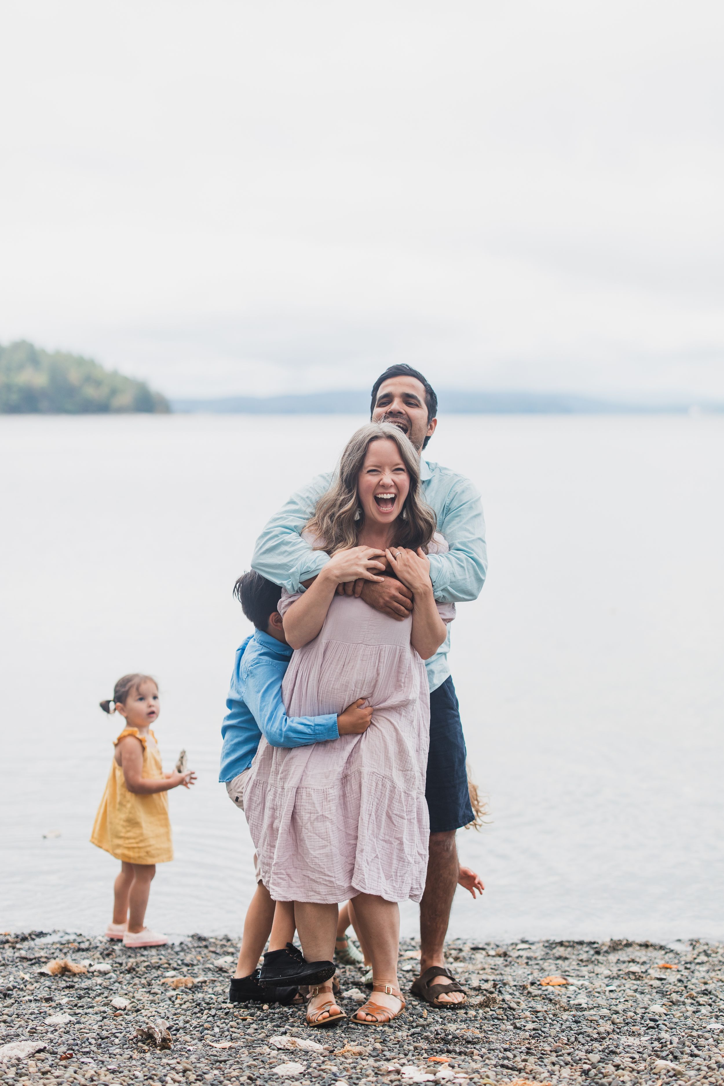 Candid family photo sequence showing joyful moments on a pebbled beach by the water.