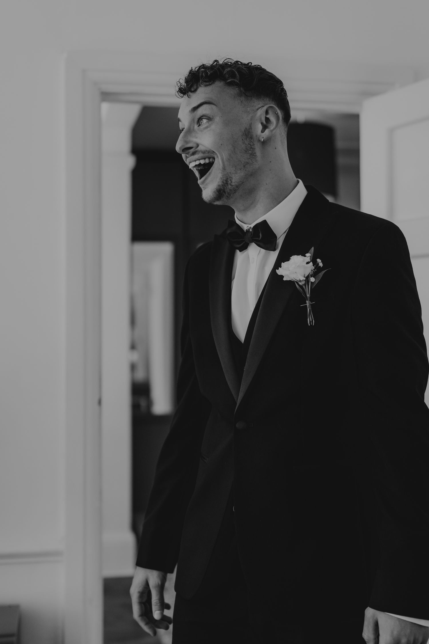 A series of formal black and white photographs showing people in dark suits standing in a bright interior space.
