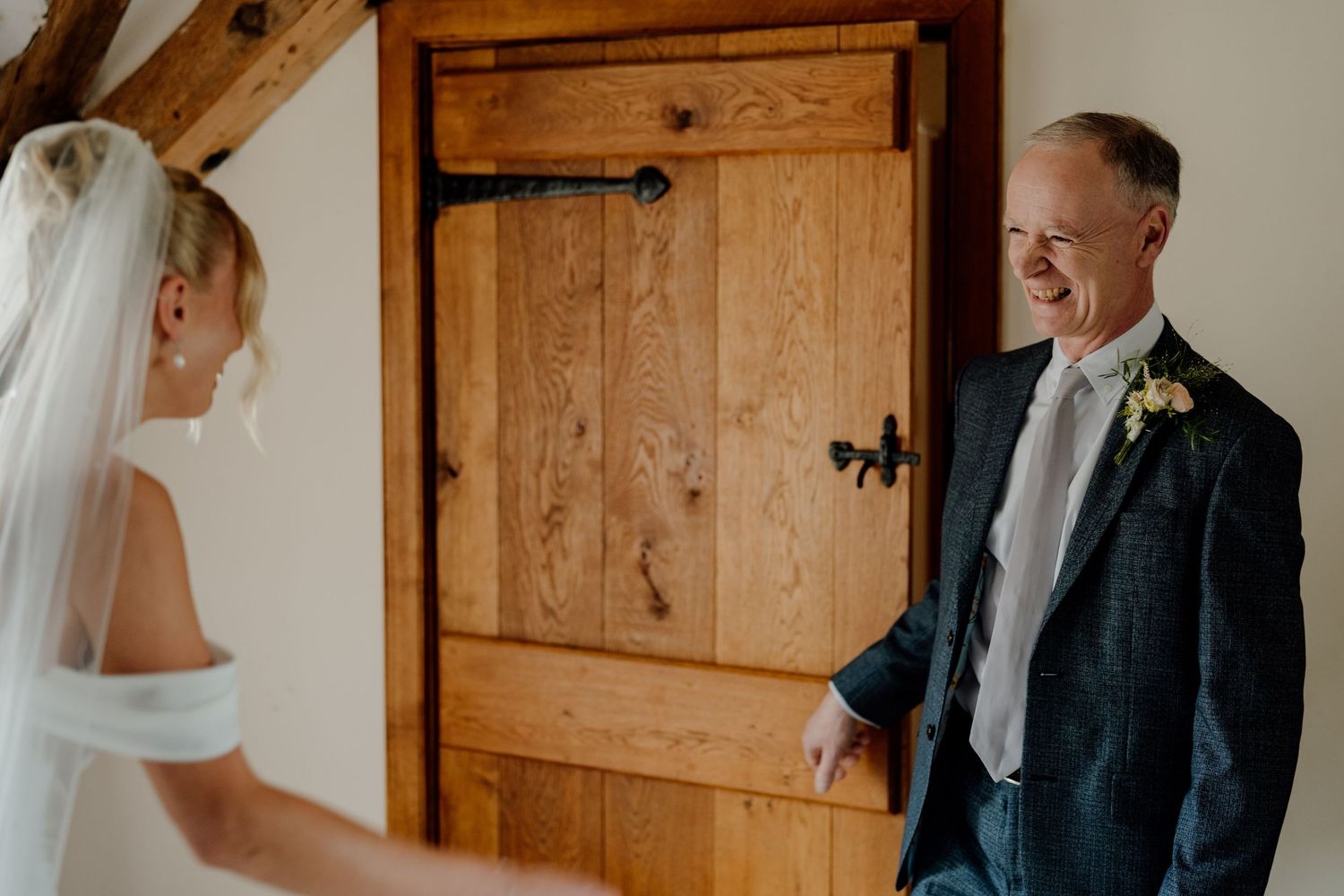 First look moment in rustic wooden room with natural lighting.