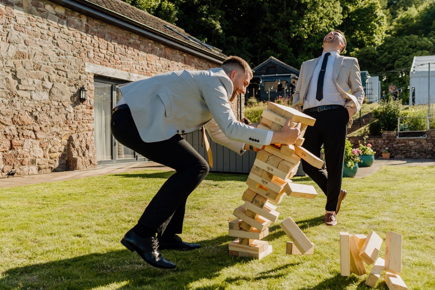 People playing outdoor wedding games and activities on a grassy lawn at a wedding.