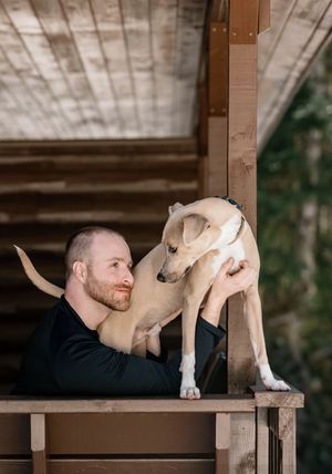 Man and dog looking at each other on a portch.