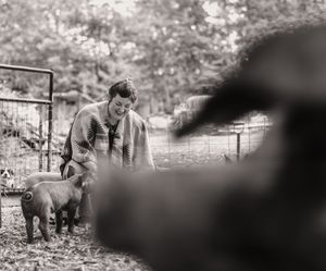 Woman playing with pigs.