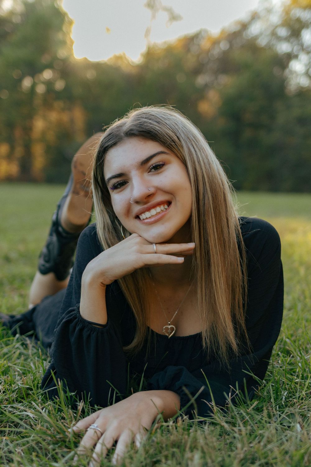 Casual outdoor portraits on grass with natural sunset lighting.