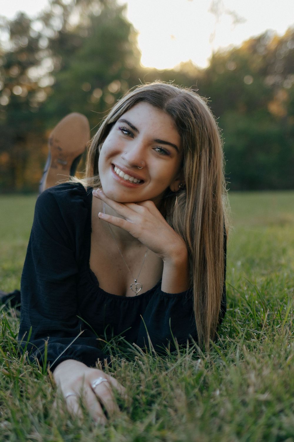 Relaxed outdoor photoshoot in a grassy field during golden hour.