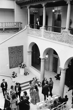 The Father of the Bride overlooks the grand hall of Cuneo Mansion where guests mingle.