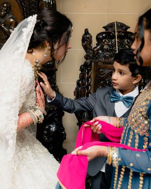 A bride shows her necklace to young wedding guests at Cuneo Mansion.