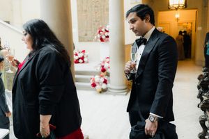 Guests sip champagne before the wedding ceremony in the grand hall of Cuneo Mansion.