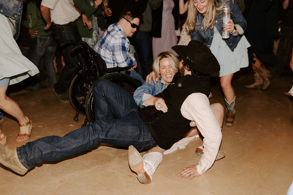 People dancing and having fun on a wooden dance floor at a lively social gathering.