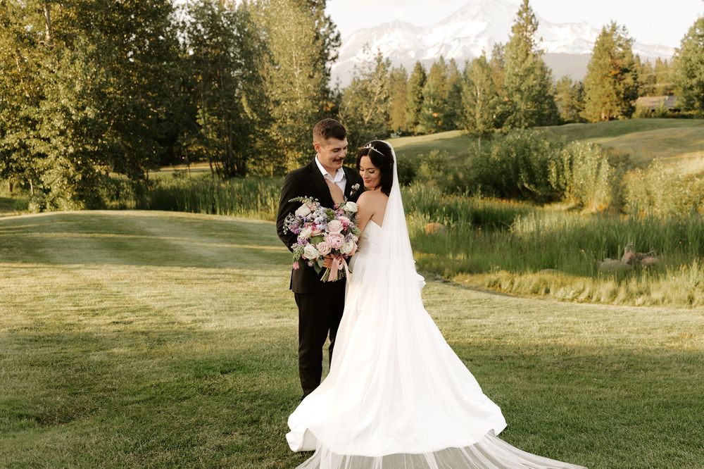 A couple shares romantic moments in a golden sunlit meadow during their wedding photo session.