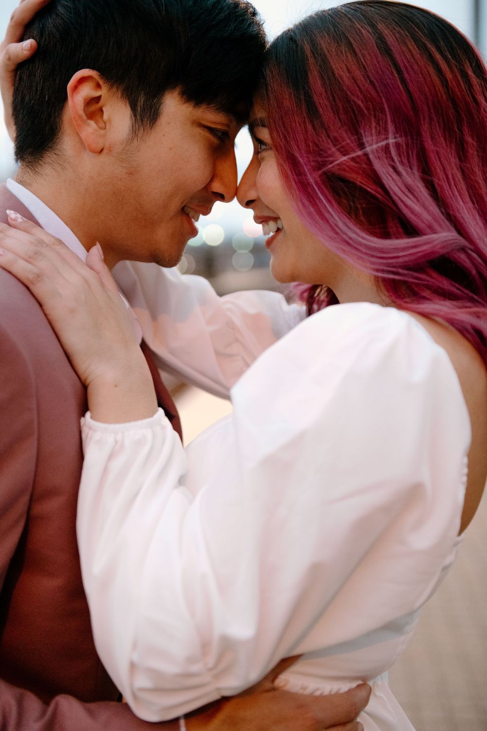 A romantic couple shares intimate kisses in a series of tender moments captured in white and pink tones.