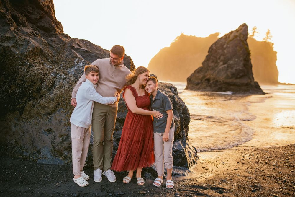 Family joyfully hugging during their family adventure photography session at Ruby Beach in Olympic National Park near Seattle, Washington