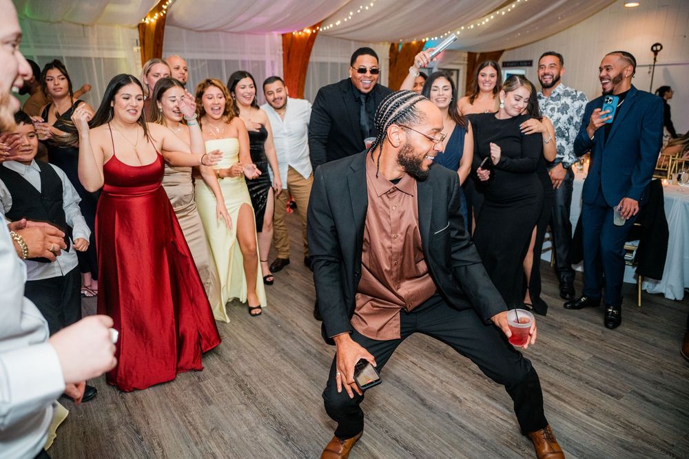 Energetic dance party at wedding reception with guests in formal attire.
