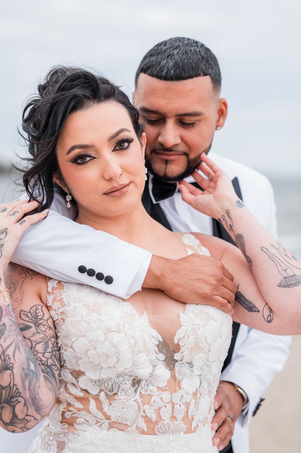 Romantic beachside wedding portrait with lace dress details.