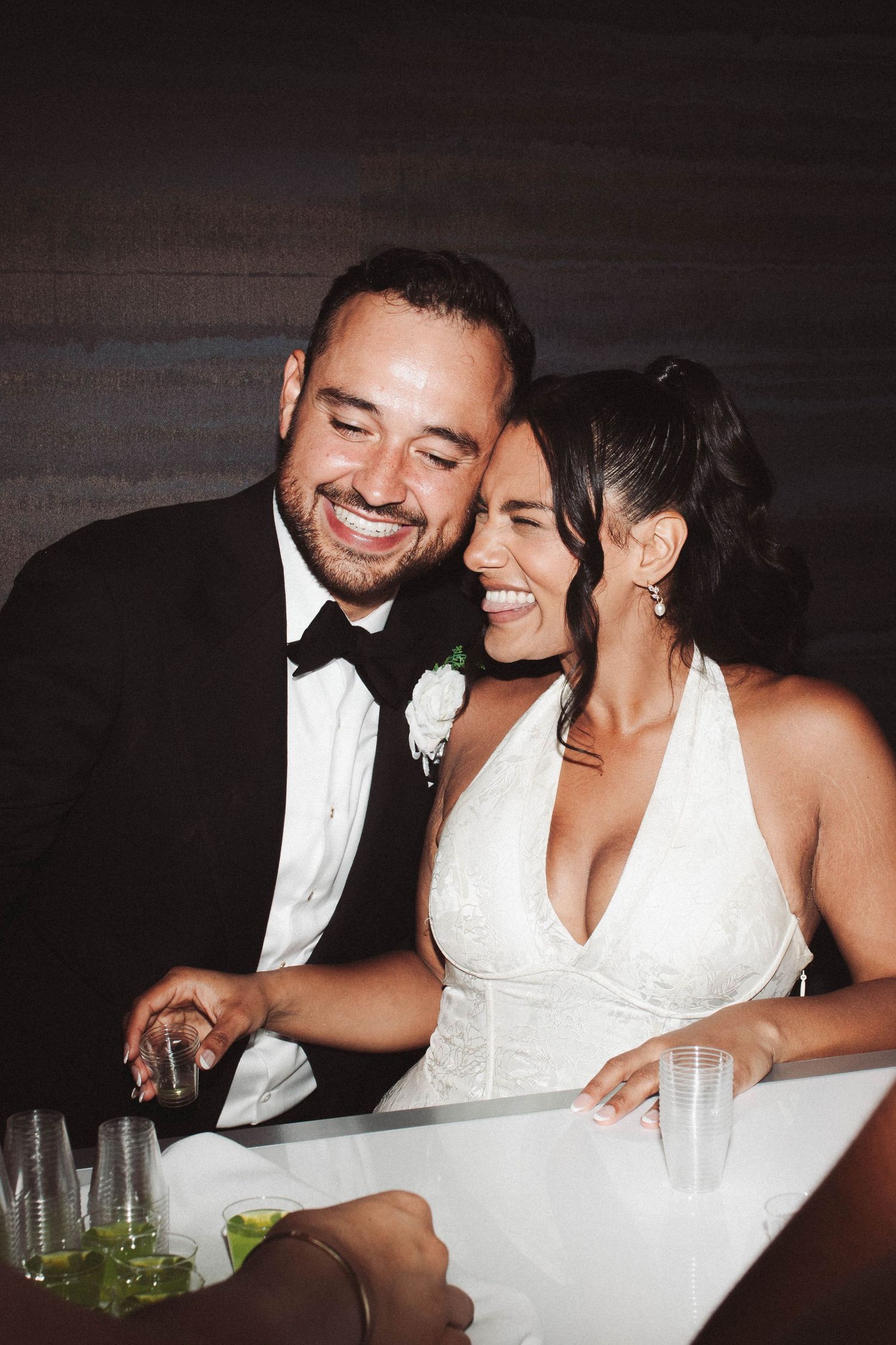 A couple shares an intimate dance at their wedding reception, with the bride in white and groom in black suit.