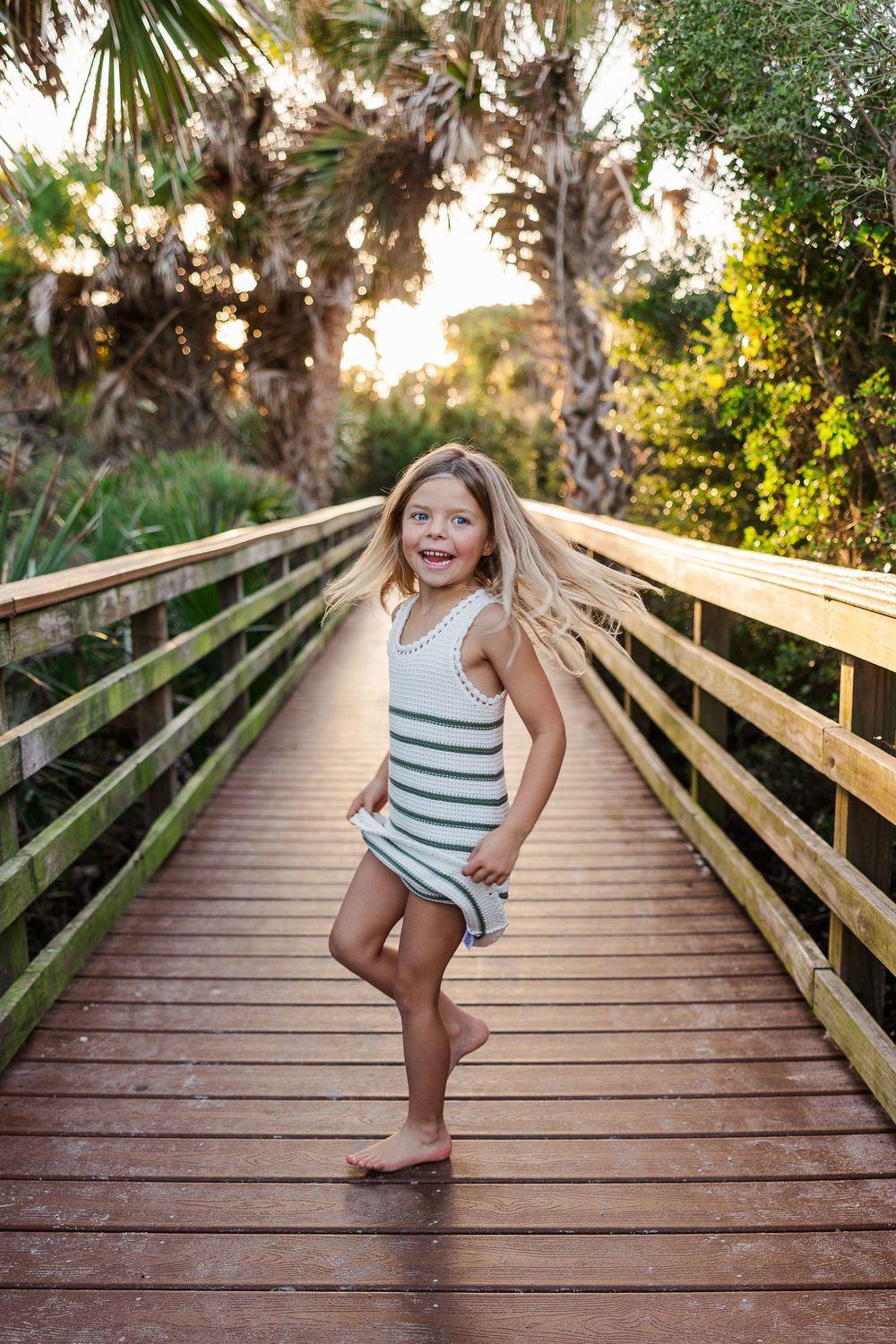 A series of photos showing a joyful moment on a wooden boardwalk surrounded by palm trees at sunset.