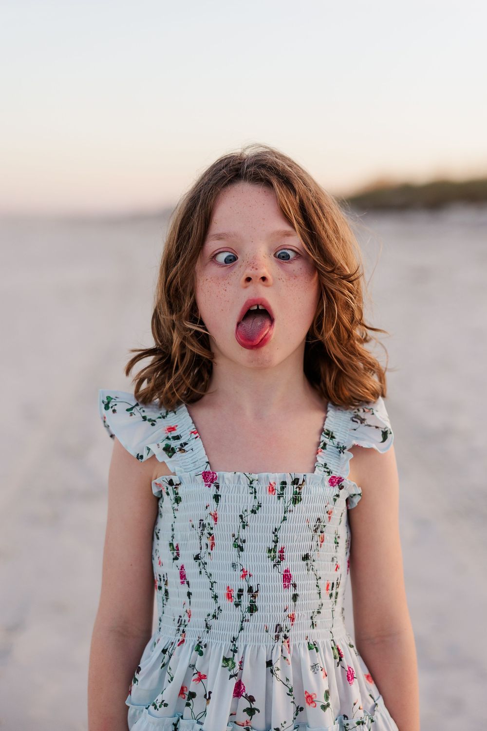 A series of playful expressions and silly faces shown in a sequence of beach portraits at sunset.