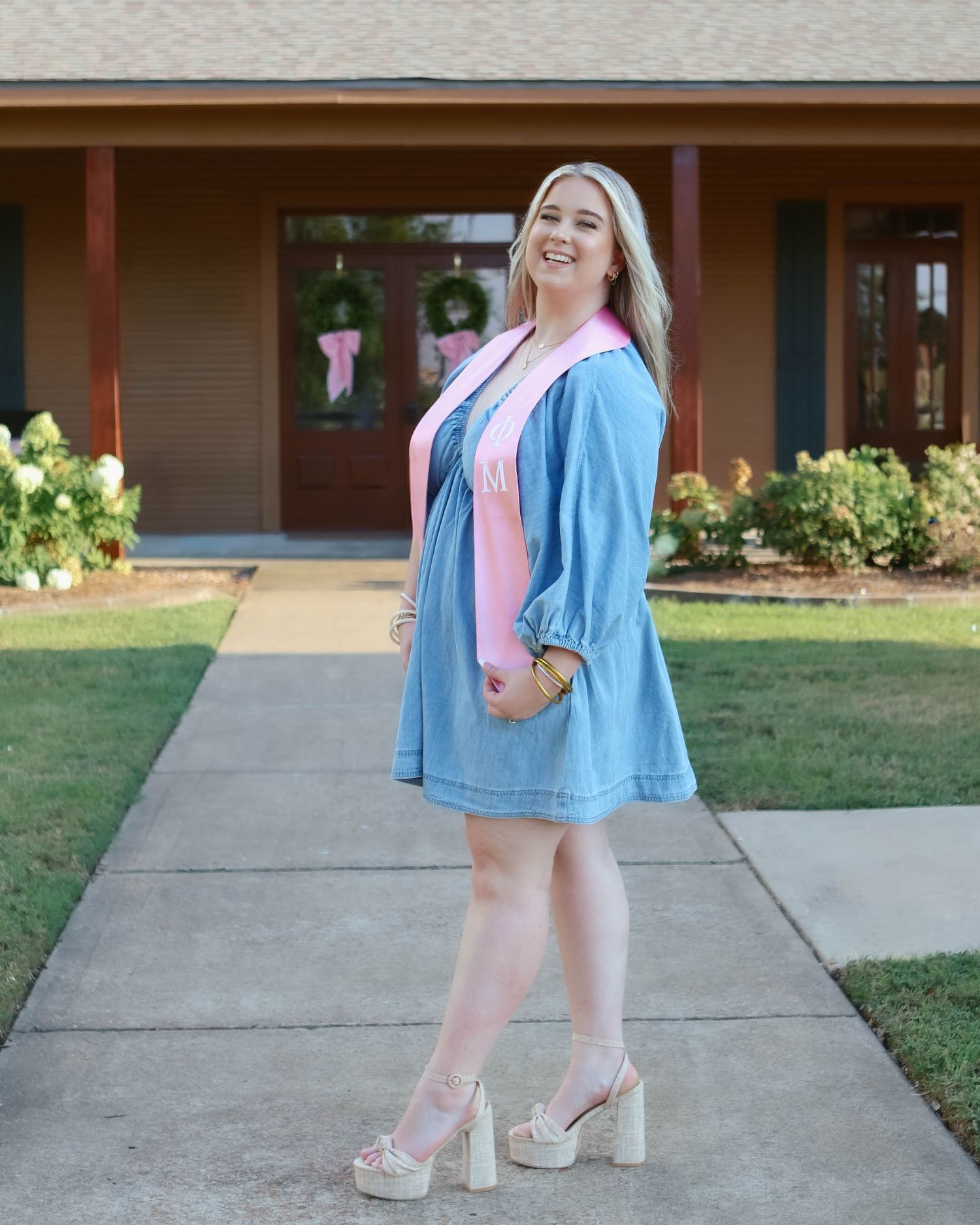 Walking shots outside a brick building wearing denim and platform shoes.