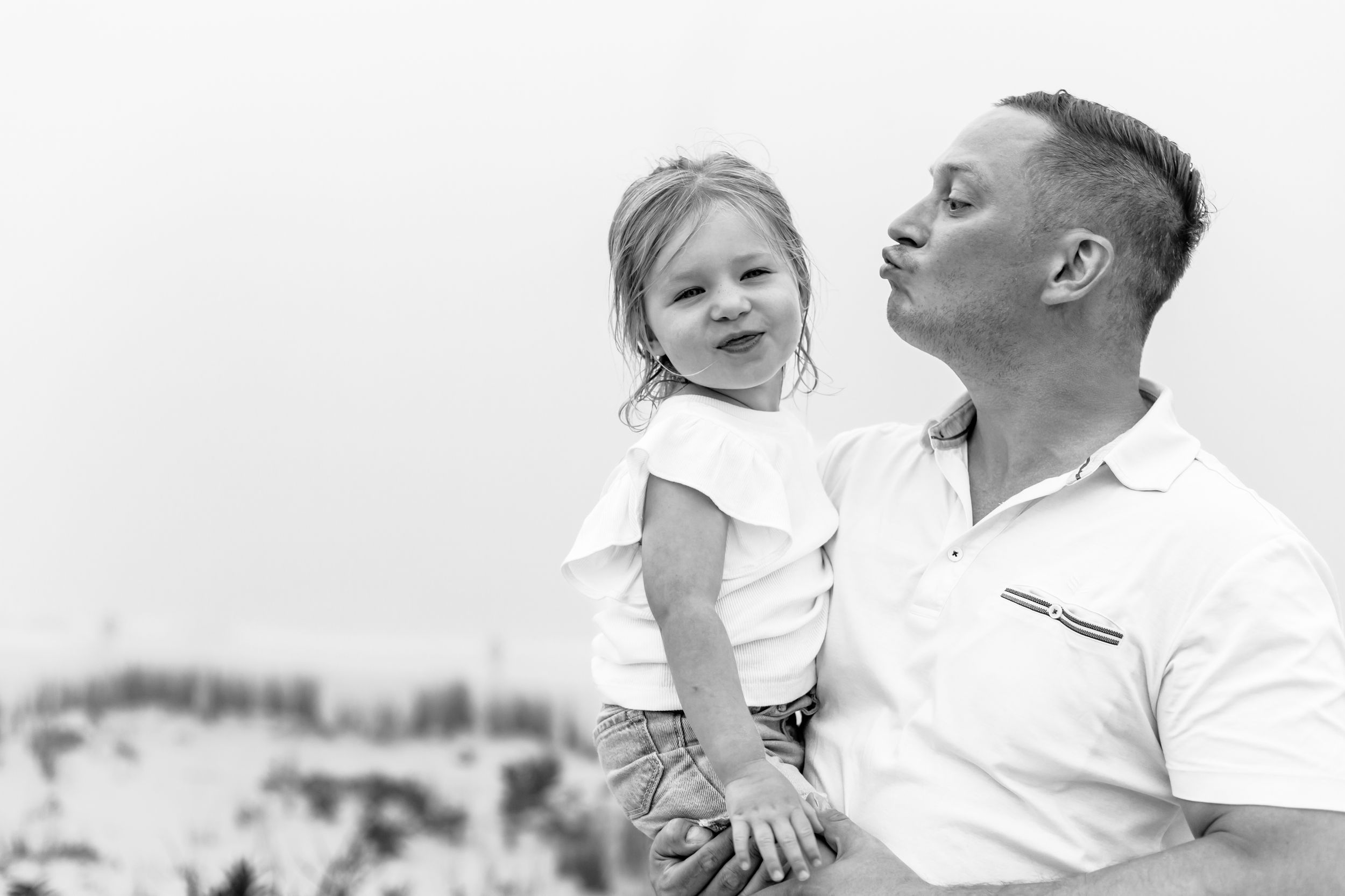 Black and white portrait of joyful family moments at the beach.