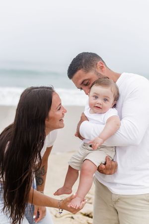 Sweet candid moments of a family playing and bonding on a sandy beach.